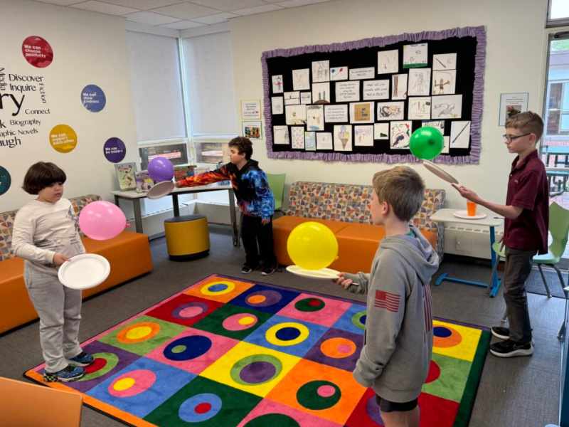 Students balancing balloons on paper plates. 2024 Summer Olympics,